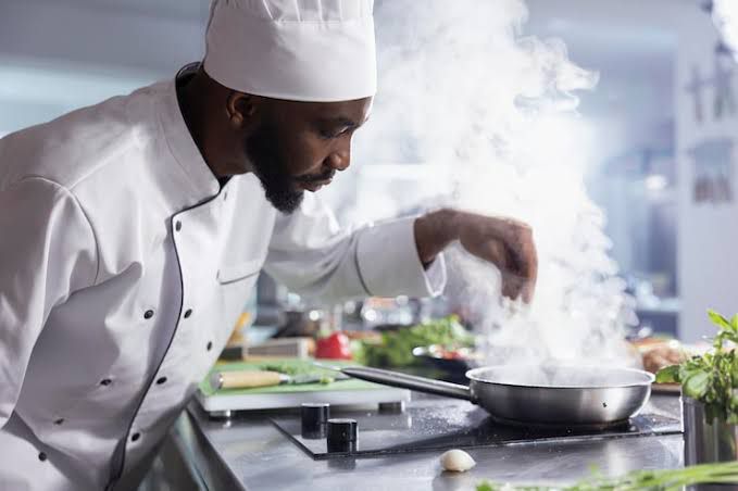 Chef tending a steaming pan